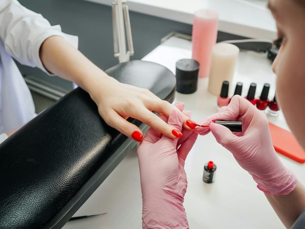 Young woman getting manicure in beauty salon